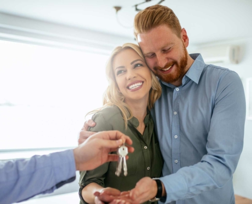 Happy-couple-getting-keys-to-new-house